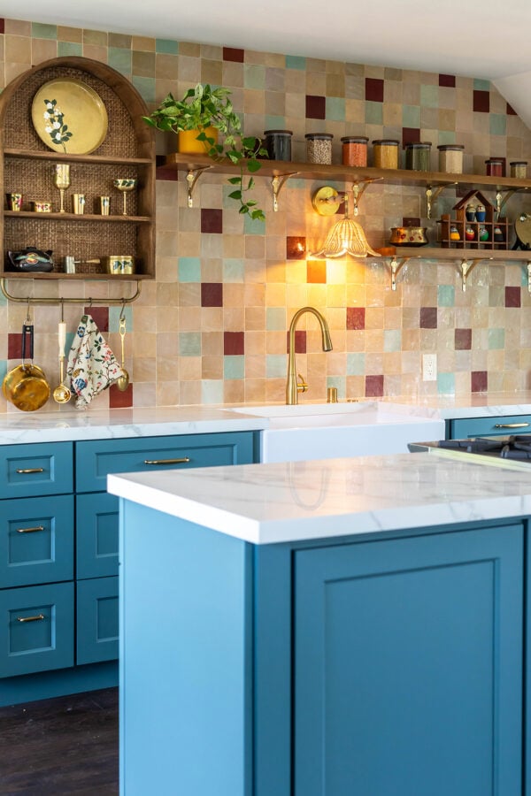 a kitchen with colorful tiles in the back