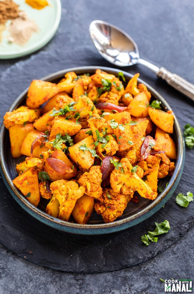 potatoes and cauliflower tossed in spices and served on a plate