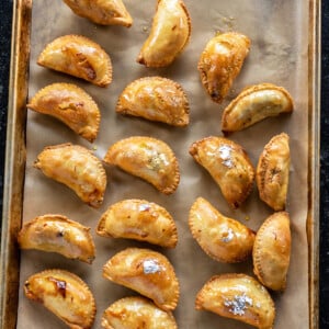 gujiyas arranged on a baking tray