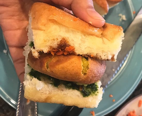 batata vada sandwiched between a dinner roll (pav)