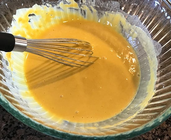 a batter being whisked with a wire whisk in a bowl