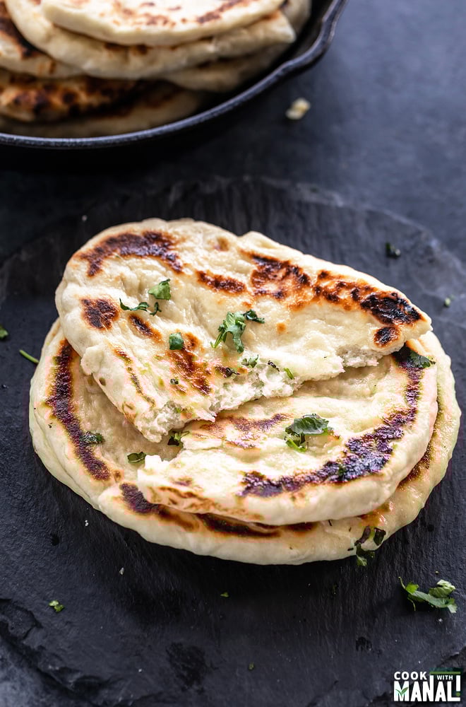 a naan torn apart into two to show the texture of the naan