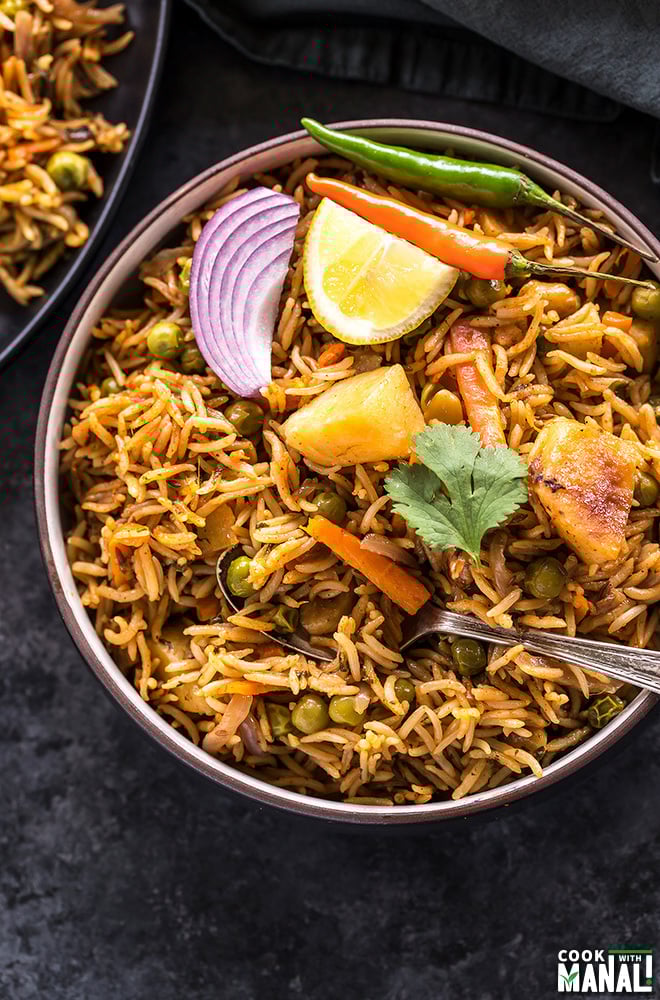 overhead shot of vegetable biryani in a black bowl
