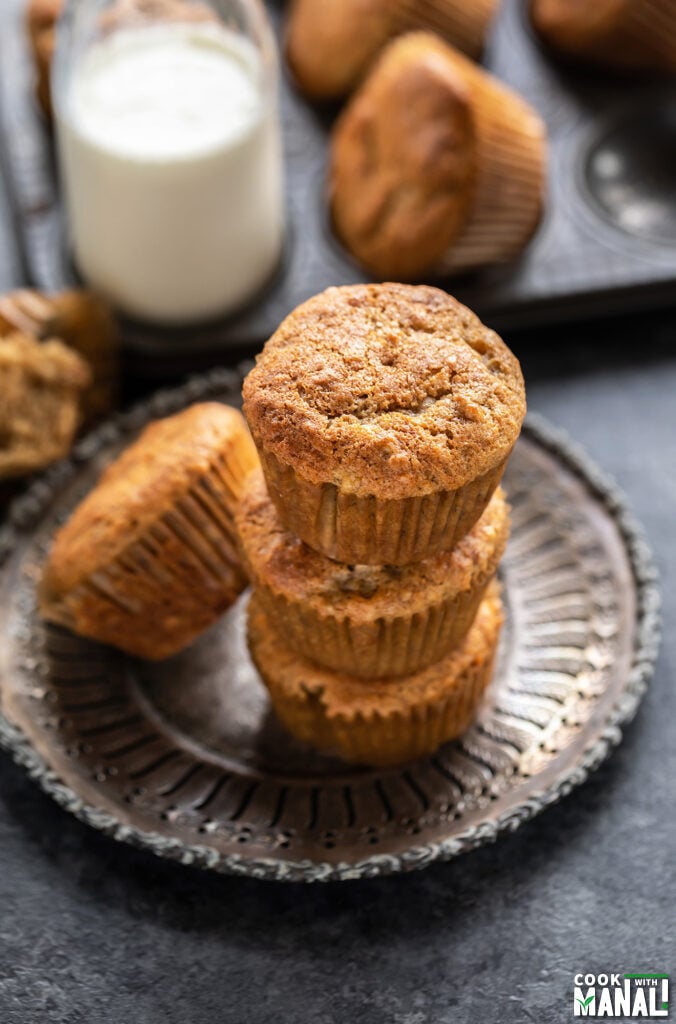 3 muffins stacked together with bottle of milk in the background