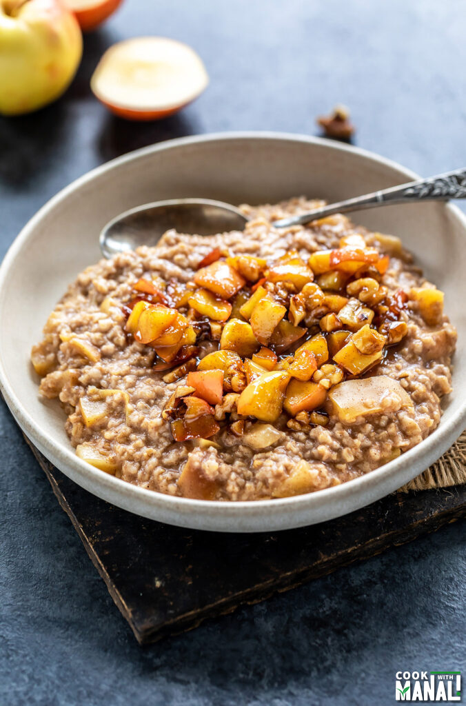 oatmeal served in a cream color bowl topped with caramelized apples
