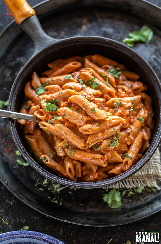 creamy makhani pasta in a skillet with a spoon