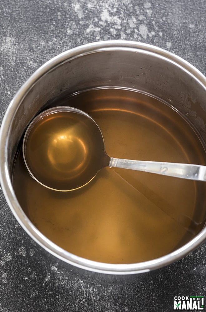 instant pot vegetable stock with a ladle