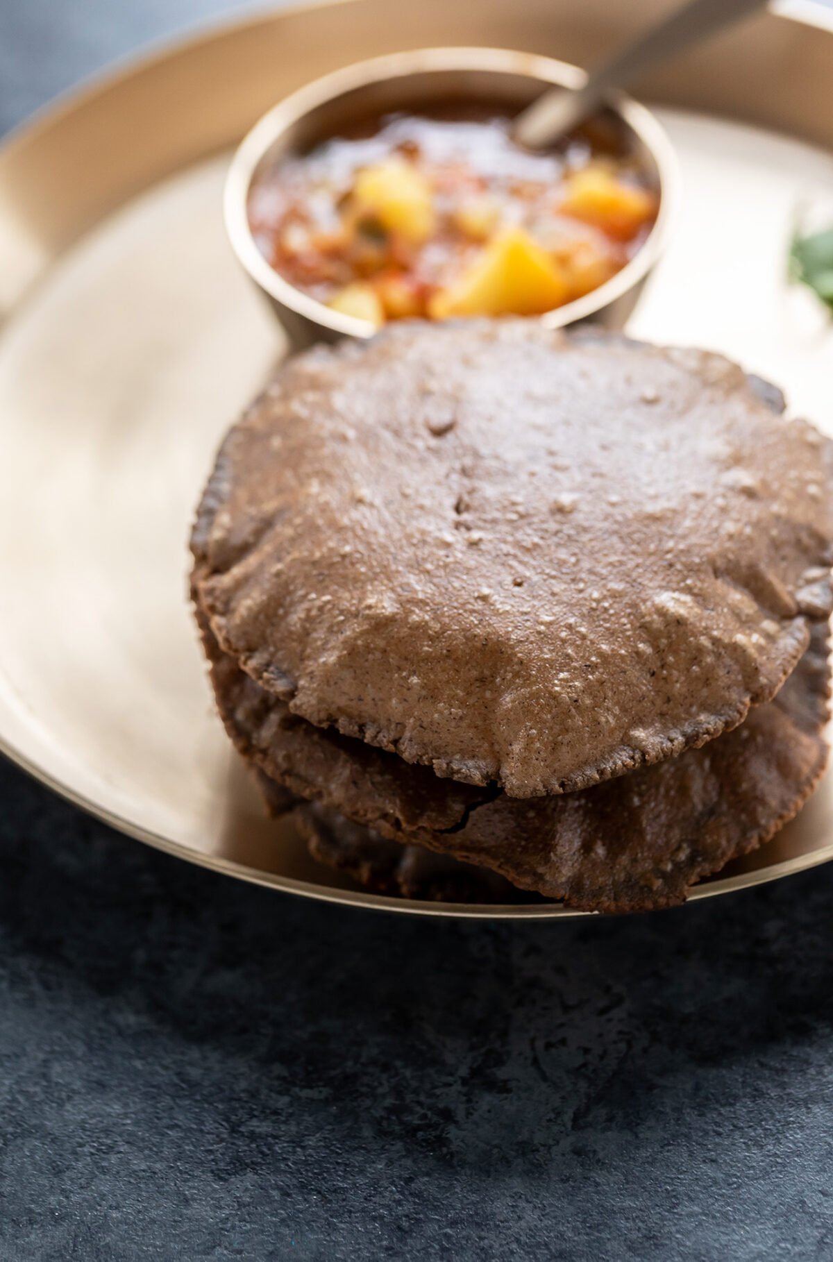 kuttu puri served with potato curry in a bronze plate