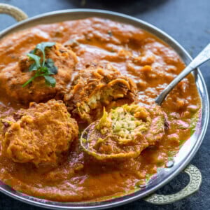 lauki kofta curry served in a copper dish with one kofta cut to show the inside