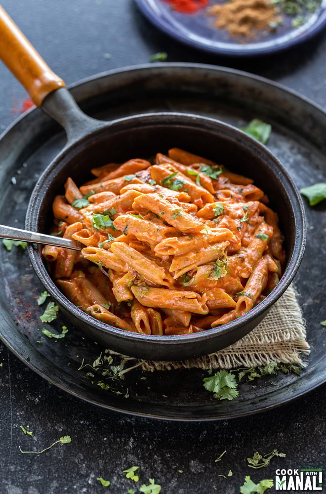 makhani pasta served in a black skillet with a spoon