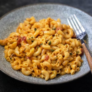 masala mac and cheese in a bowl with fork placed on the side