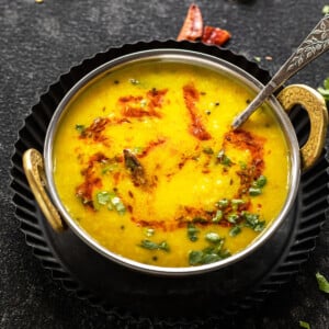 moong dal tadka in a copper kadai with a garnish of cilantro and cumin