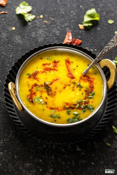 moong dal tadka in a copper kadai with a garnish of cilantro and cumin