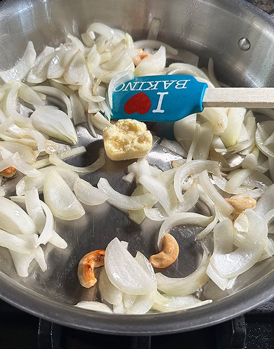 sliced white onions in a steel pan