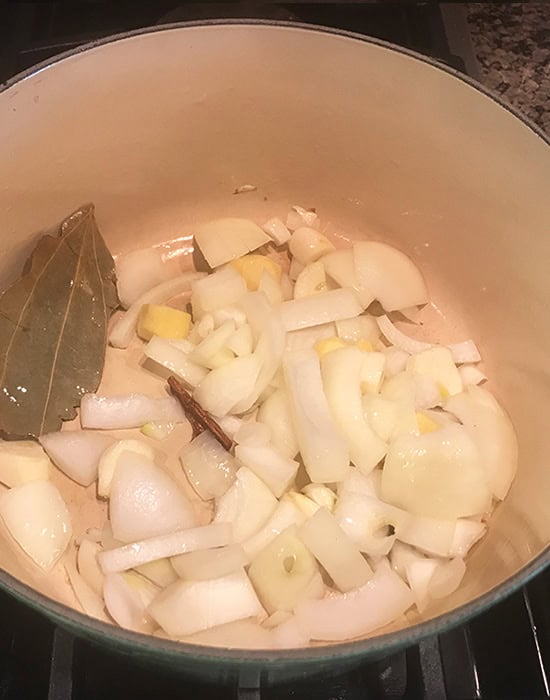 onions with whole spices in a pot