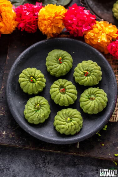 7 paan peda arranged on a plate with string of flower on the side