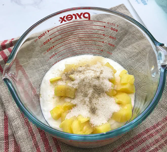 ingredients for pineapple ginger lassi in a large measuring mug