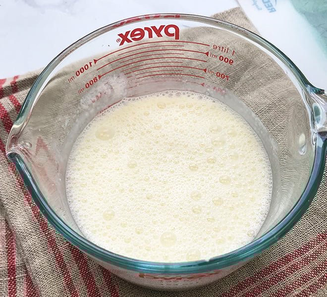 pineapple lassi in a large measuring mug