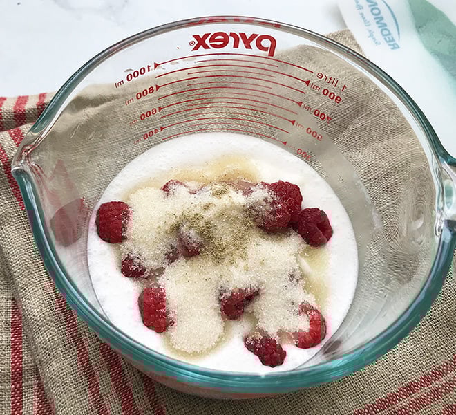 ingredients for raspberry coconut lassi in a large measuring jar