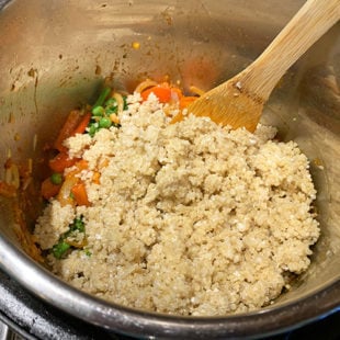 cooked quinoa being added to a pot