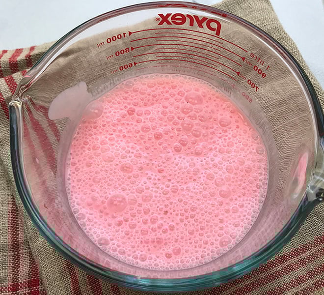 rose lassi in a large measuring jar