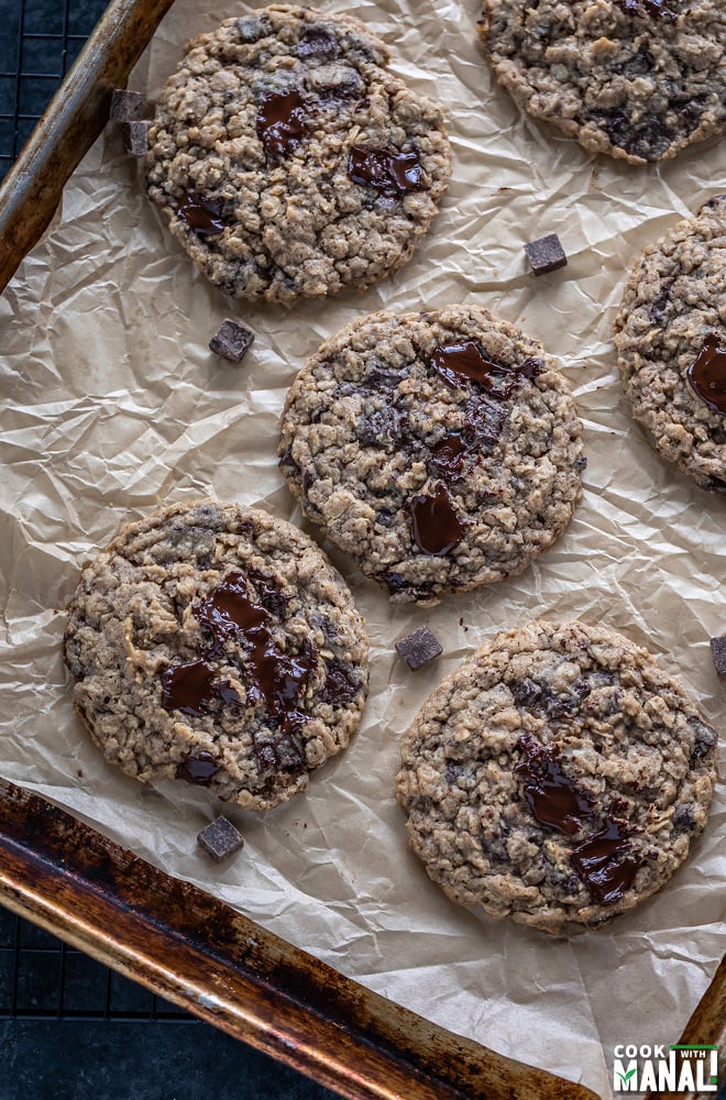 oatmeal chocolate chunk cookies on parchment paper with melting chocolate on top
