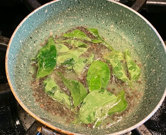mustard seeds, curry leaves in a small pan