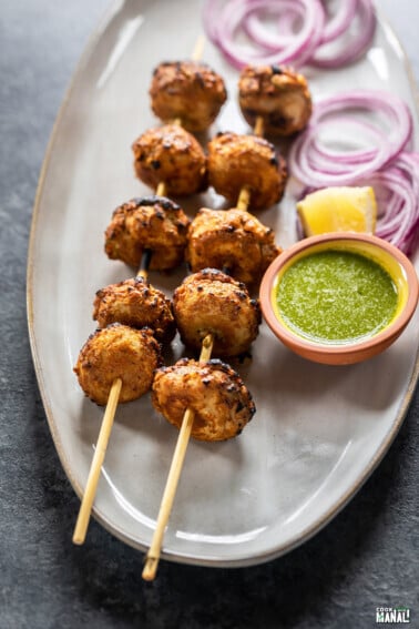 tandoori mushrooms arranged on skewer served with cilantro chutney