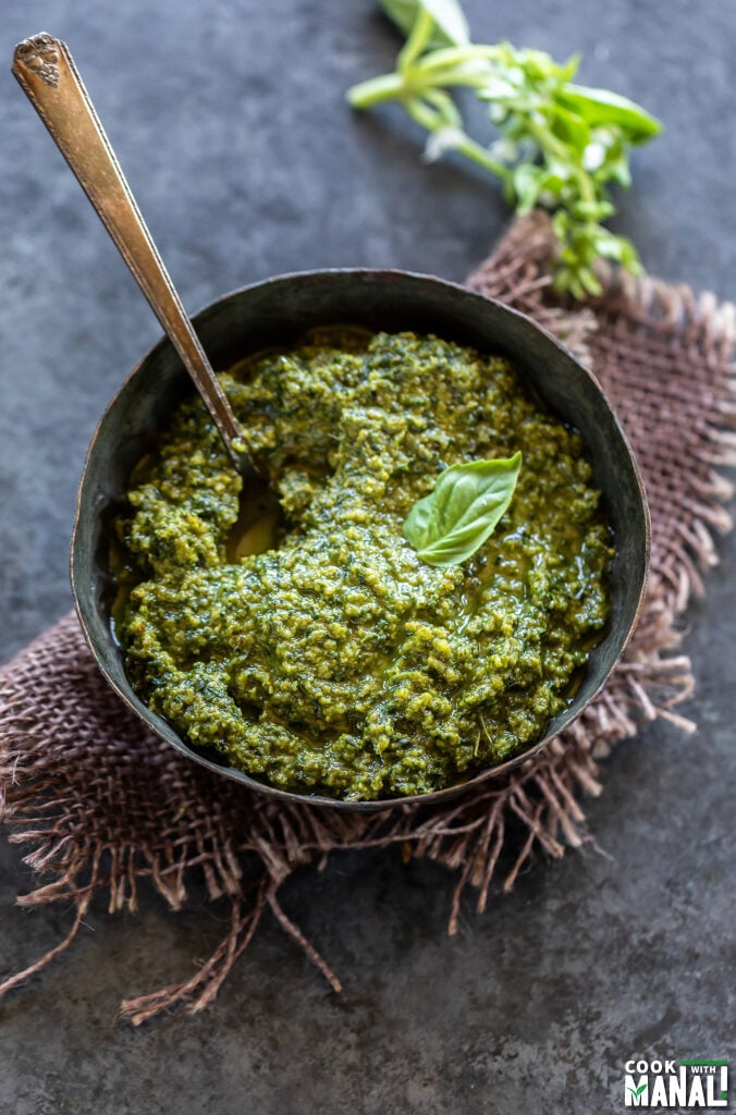 bowl of pesto garnished with a fresh basil leaf