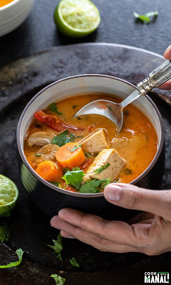 bowl of thai curry soup with a spoon ready to dig in
