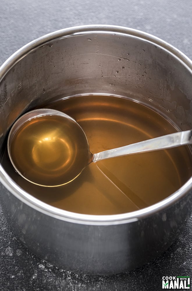 instant pot vegetable stock with a ladle