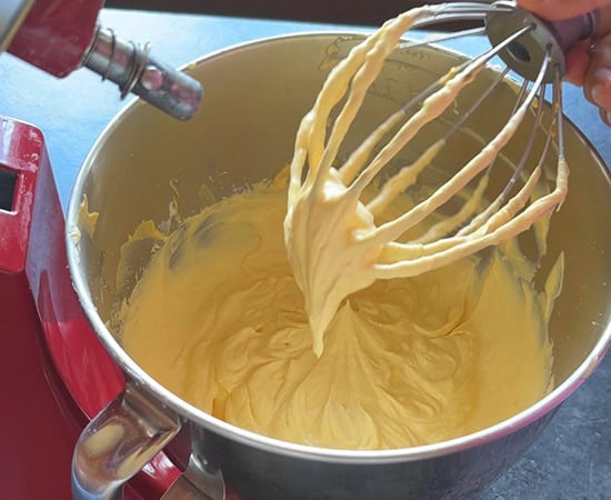 wire whisk being lifted up to show the texture of the mixture