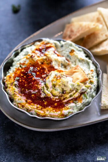 whipped paneer dip served in a antique bowl topped with honey and chopped mint